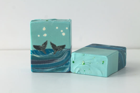 Two bars of soap, one a whale design, on a white background
