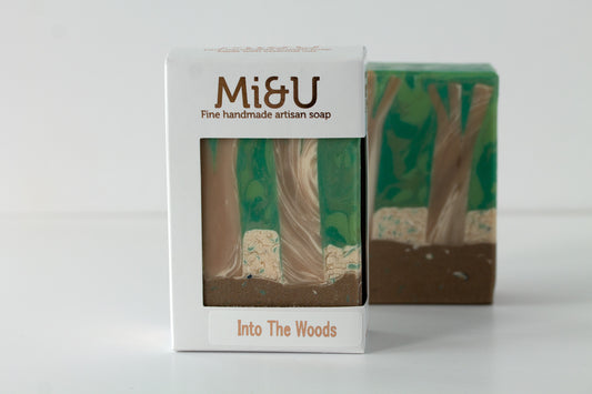 Handmade artisan soap with packaging labeled 'Mi&U Into The Woods' on a white background