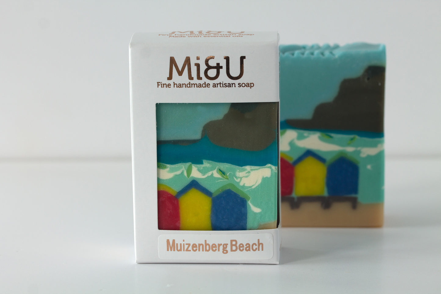 Handmade artisan soap with a beach design and packaging labeled 'Mi&U'.