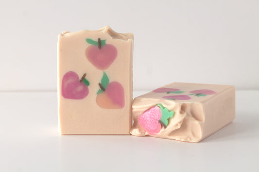 Two soap bars with peach designs on a light background