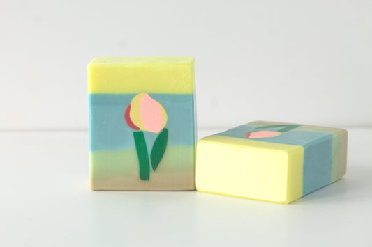 Two soap bars with tulip designs on a light background