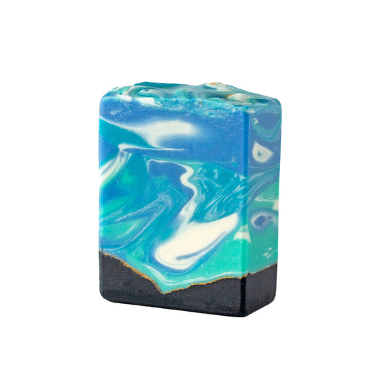 Bar of soap with oceanic swirls and gold and black on a white background
