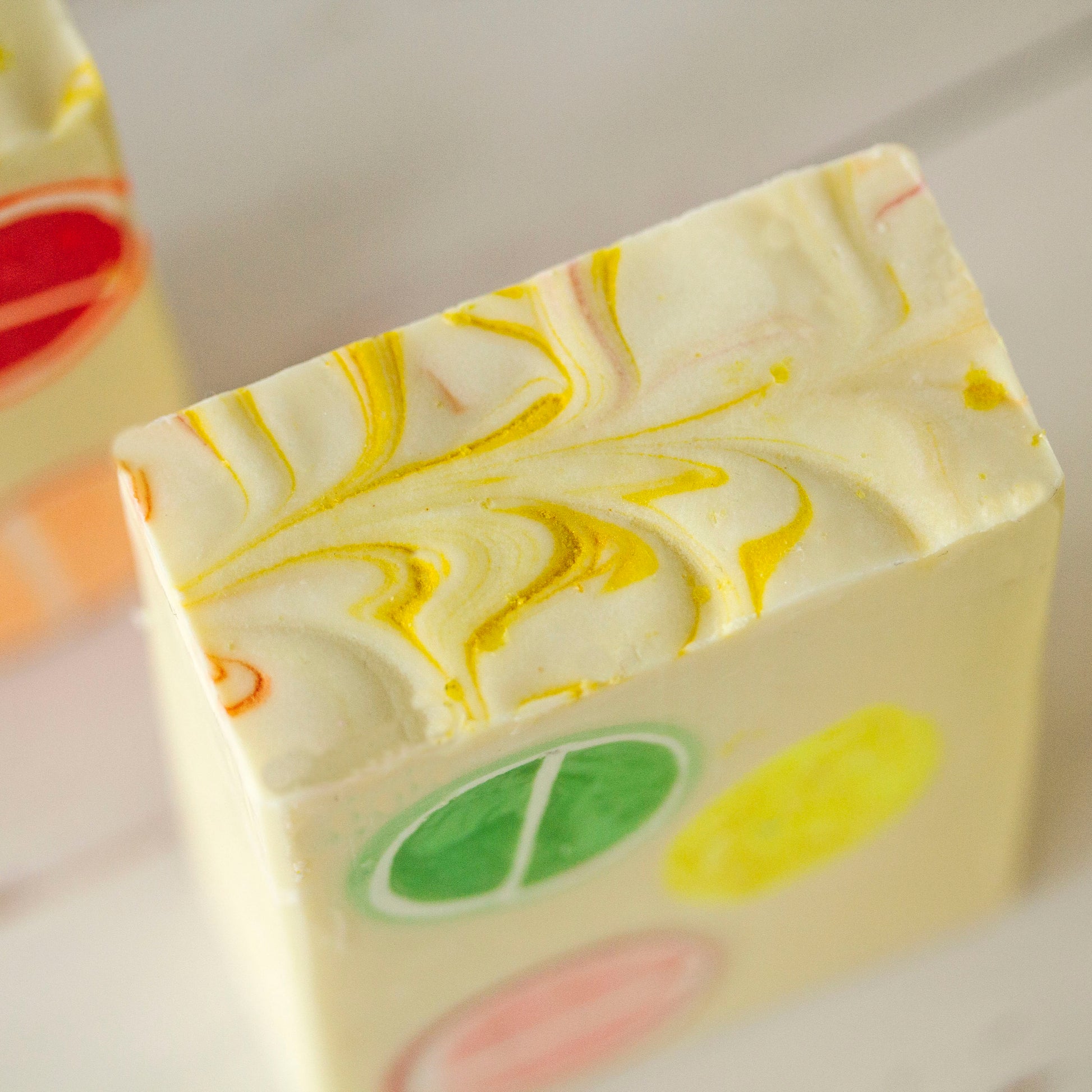 Embedded citrus soap bar with colorful swirls on a white background
