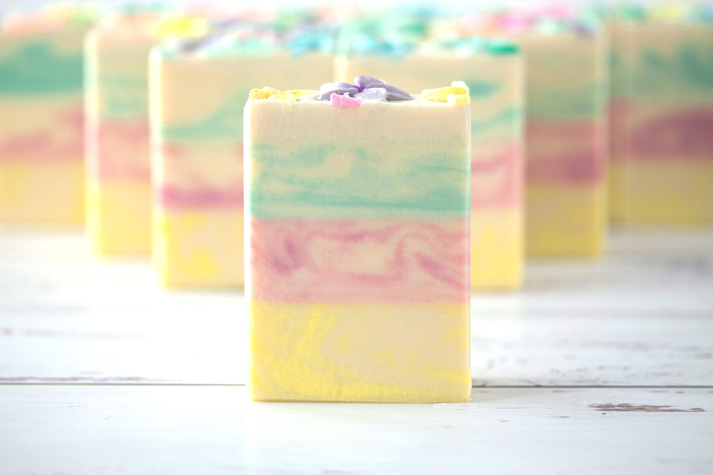 Pastel-colored soap bars on a white wooden surface