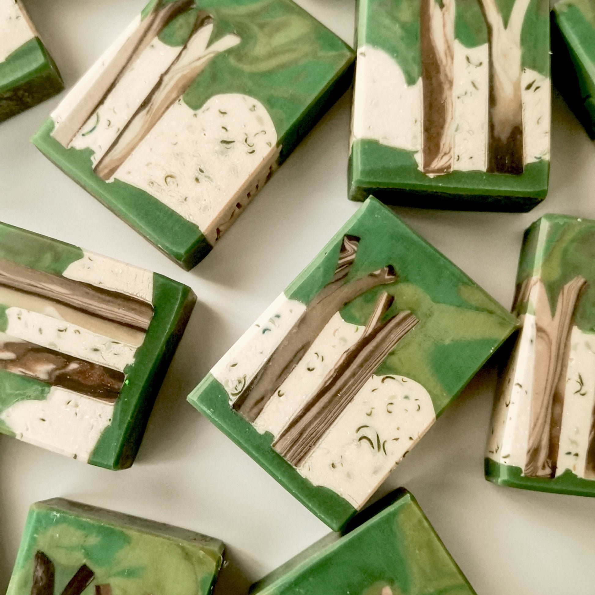 Green and beige soap bars with tree design on a white background