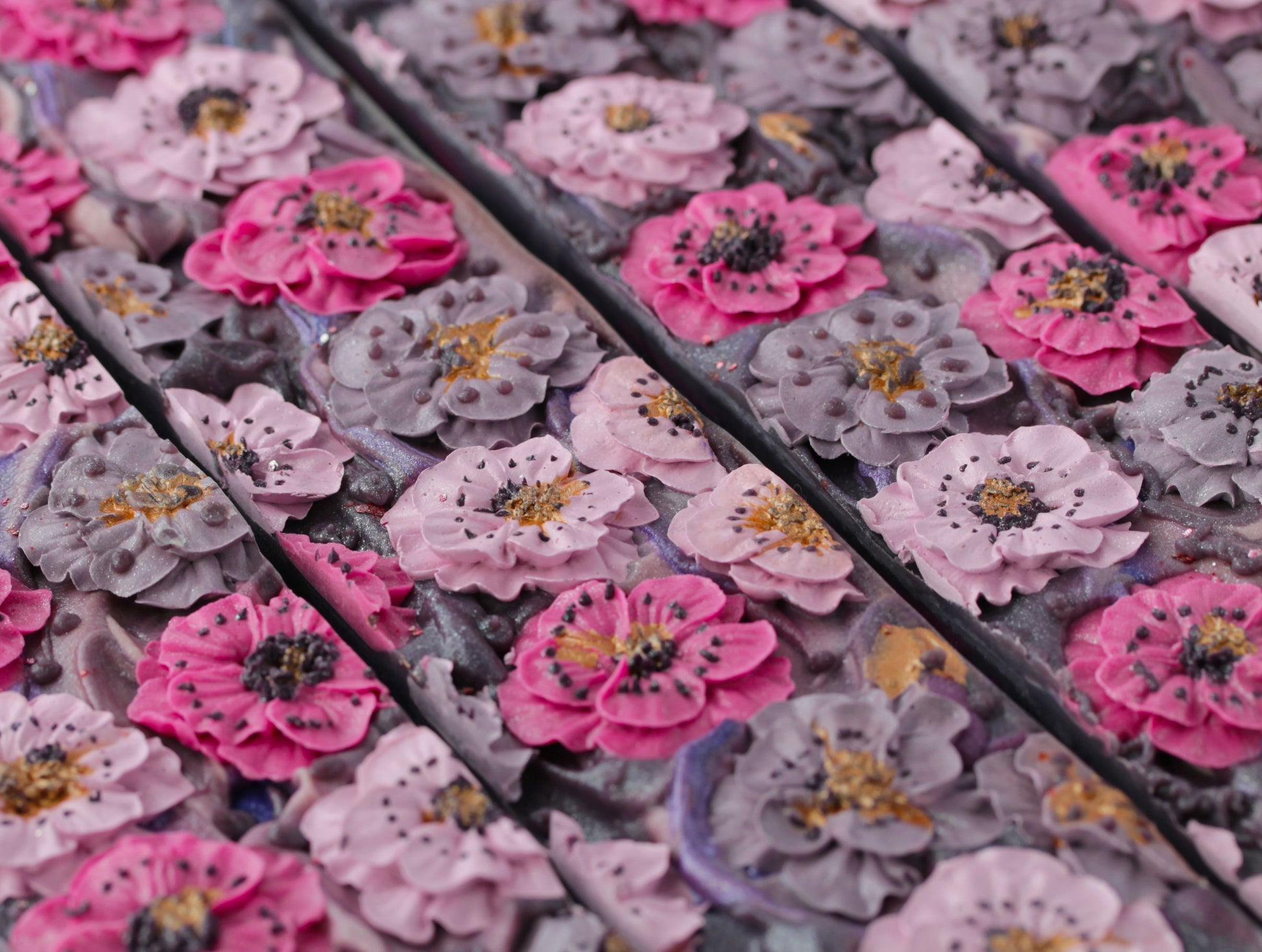 Close-up of Midnight essence soap bar with piped flowers on top.