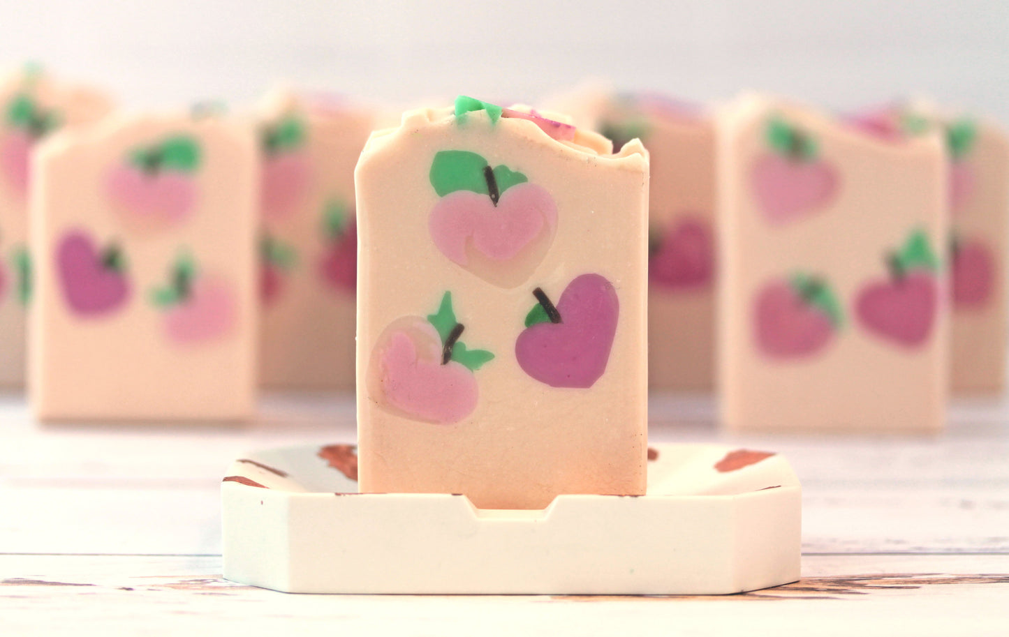 Bar of soap with a peach design on a white soap dish 