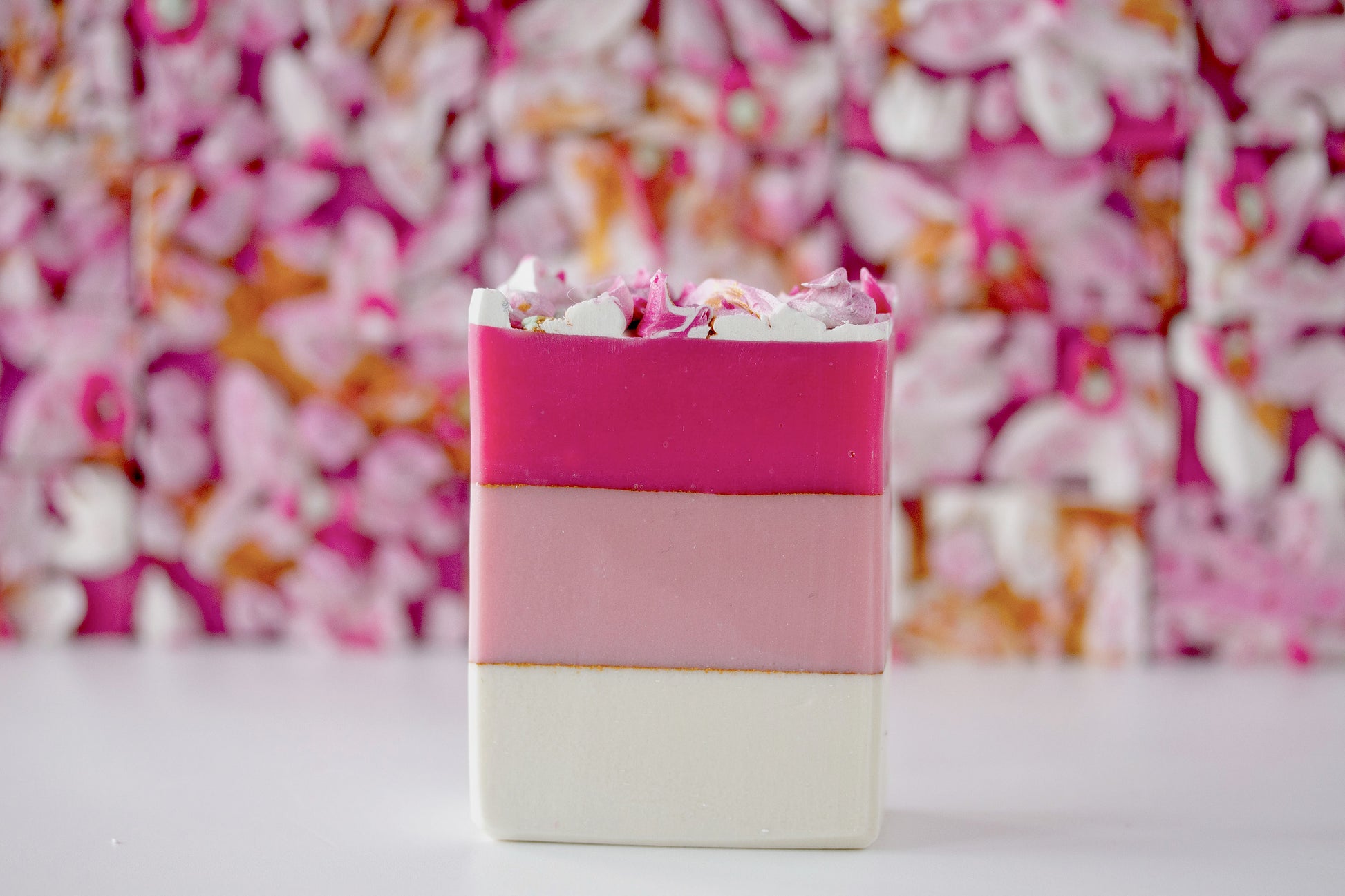 Colorful layered soap bar with a multicolored soap top background