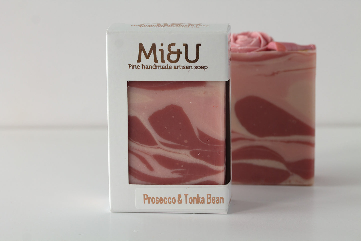 Pink marbled soap with 'Mi&U' packaging on a white background