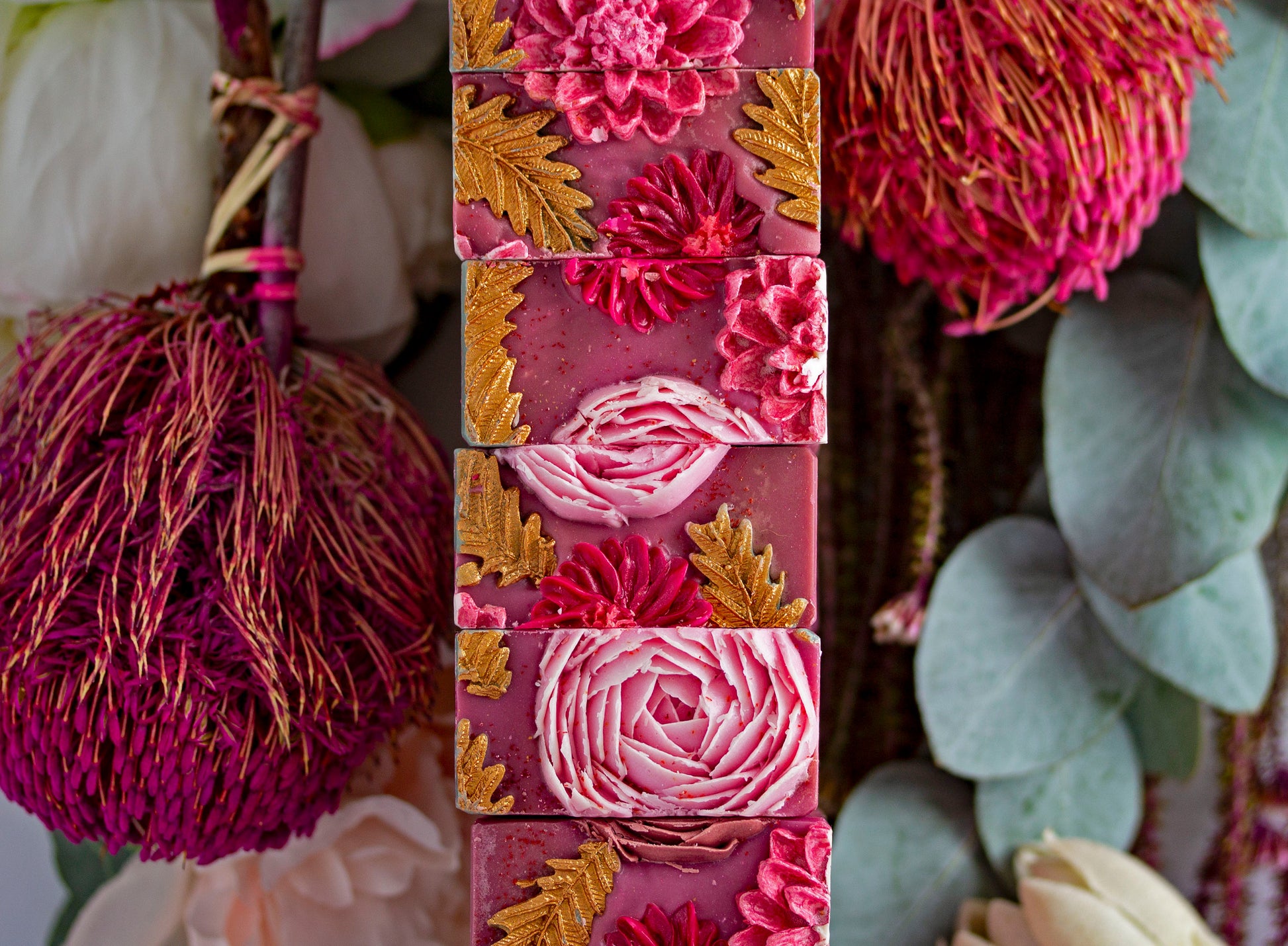 Stack of floral-patterned soap bars with natural elements in the background