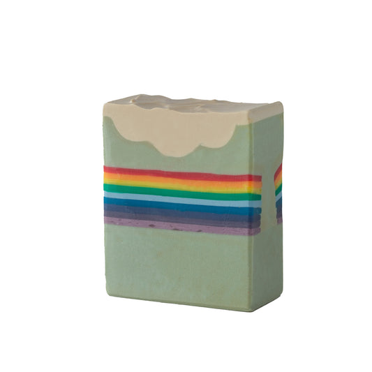 Dreamy artisan soap bar with fluffy clouds and a rainbow.