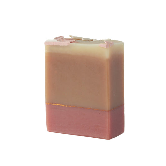 Two-layered soap bar with a gradient from beige to pink on a white background