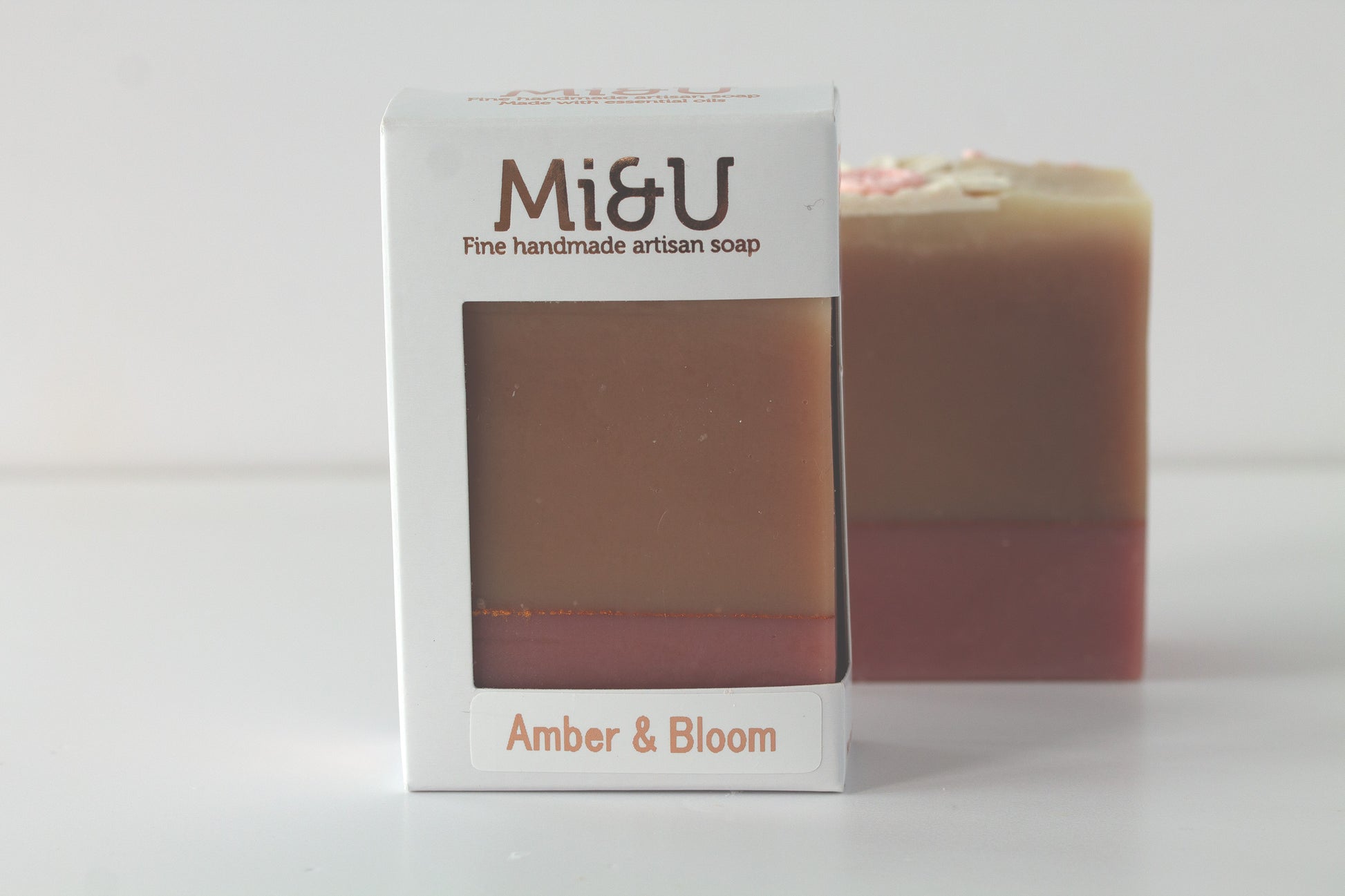 Mi&U handmade artisan soap with a bar of soap in the background on a light gray background