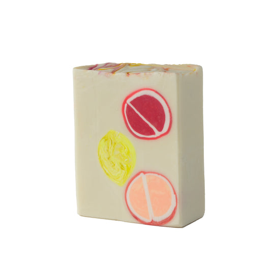 Creamy soap bar with embedded citrus fruits